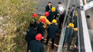 Workers and the boss inspect the construction of a prefabricated holiday resort building in mainland China.