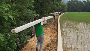 Workers carry the light weight, yet strong aluminium frame to the location of the build site.