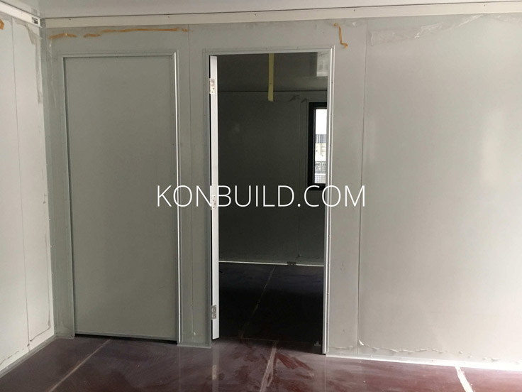 Shipping container home interior with two large doors.